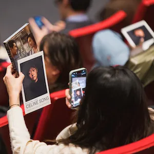 Person photographs Celine Song program. 