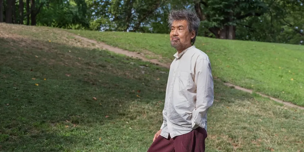 A man stands in a hilly field