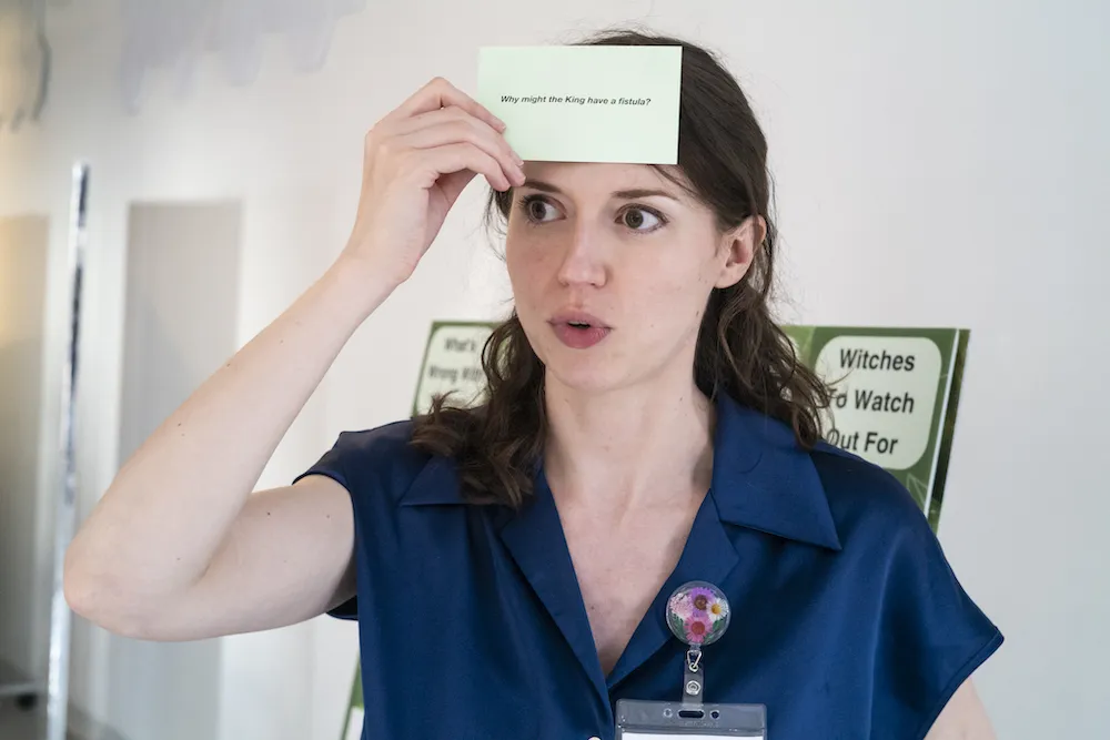 A woman holds a card up to her forehead