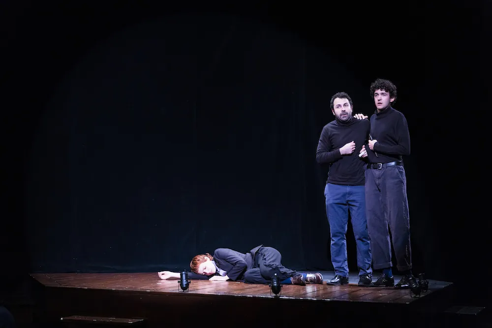 three actors perform on stage