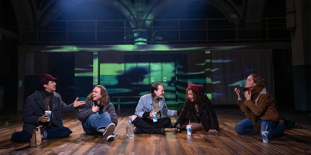 a group of actors sit on stage