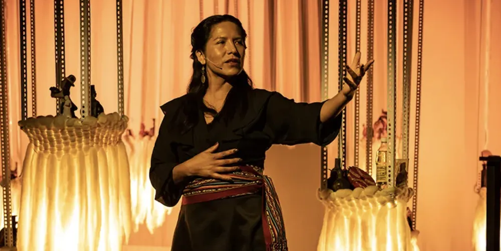 Woman gestures on stage. 