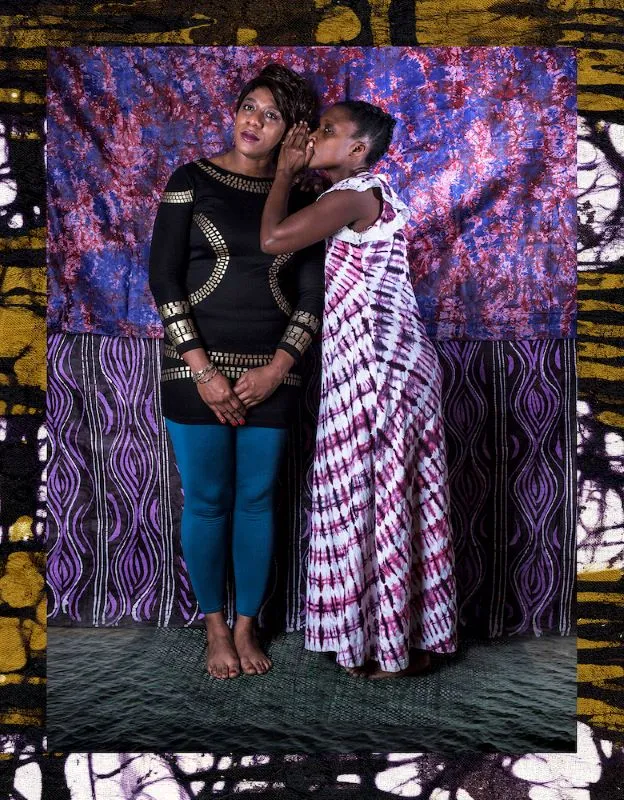 Two women standing in front of textile