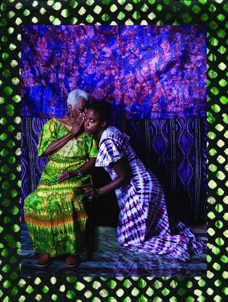 Image of a woman whispering into another woman's ear.