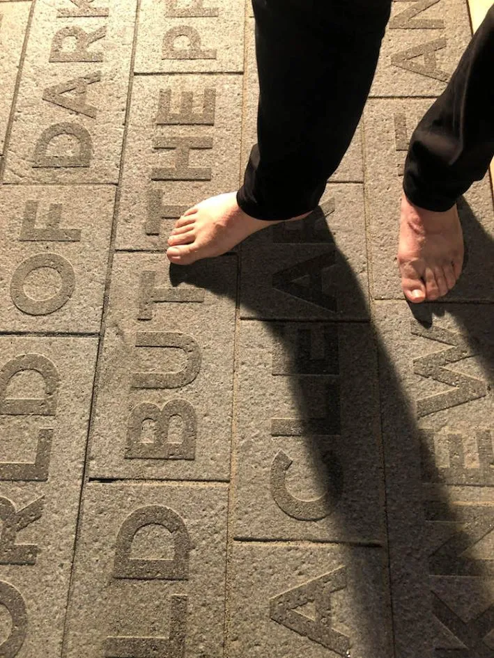 Person standing barefoot over brick.