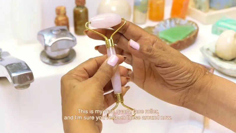 Still from HD video of hands holding a rose quartz face roller