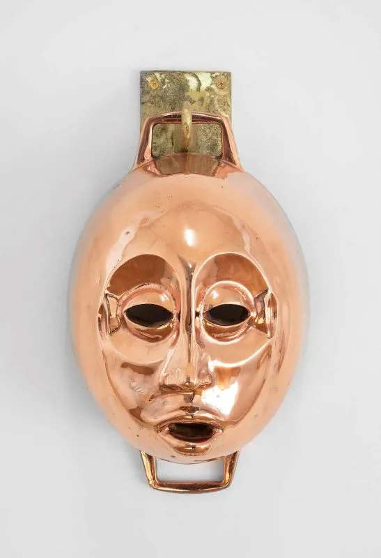 Cookware sculpture with a face
