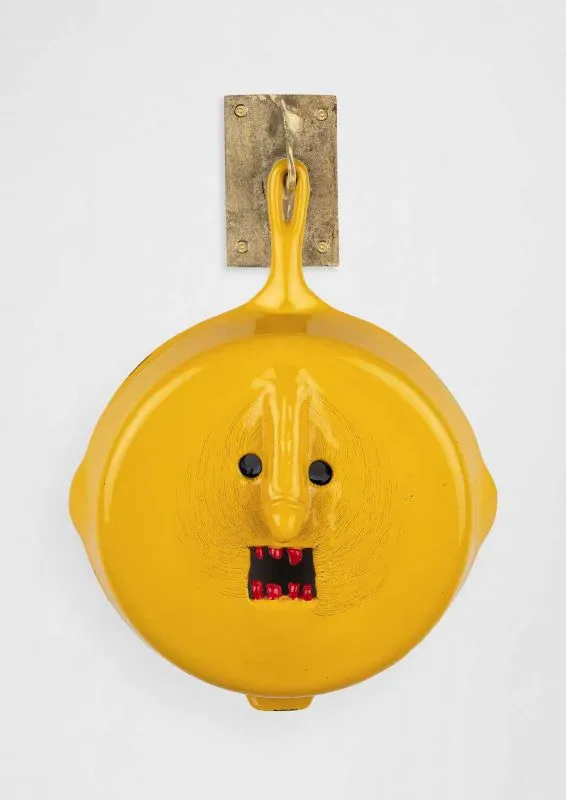 Cookware sculpture with a face