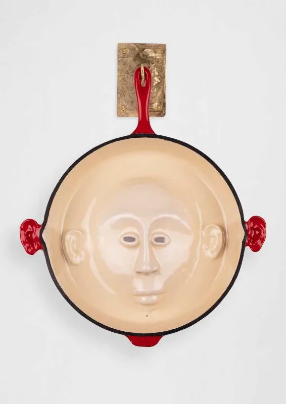Cookware sculpture with a face