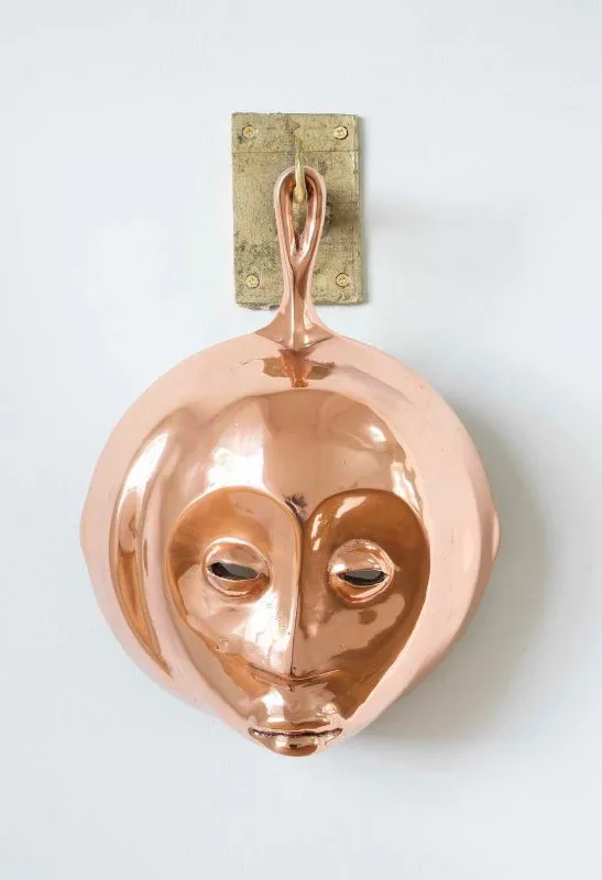 Cookware sculpture with a face