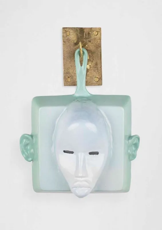 Cookware sculpture with a face