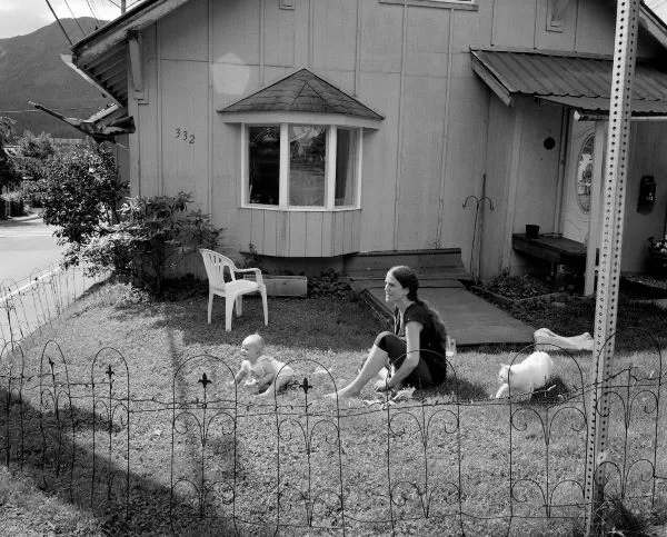 woman with cat and baby on front lawn