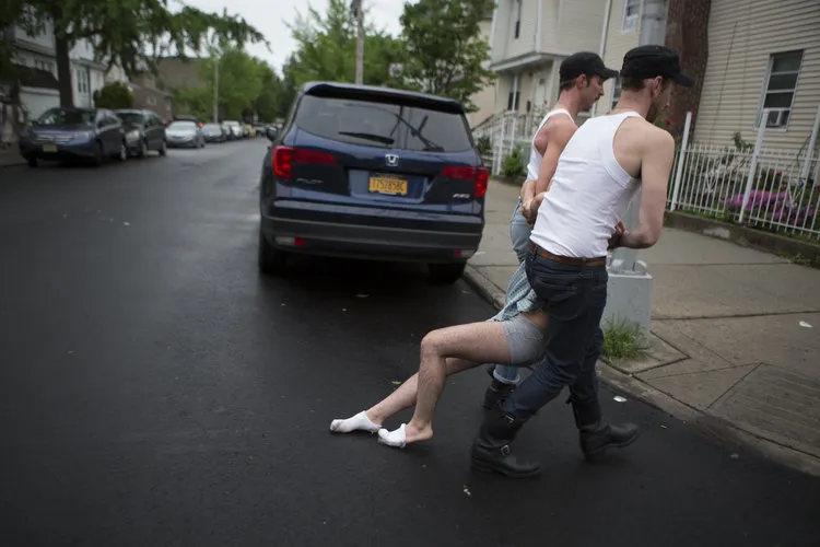 two men dragging another person away
