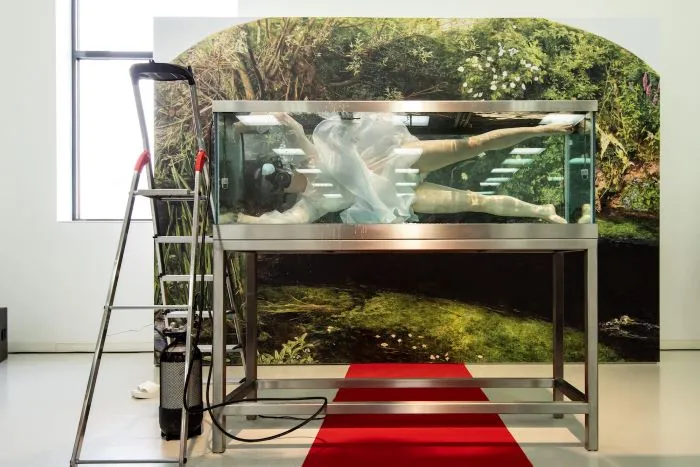 A woman submerged in a tank.