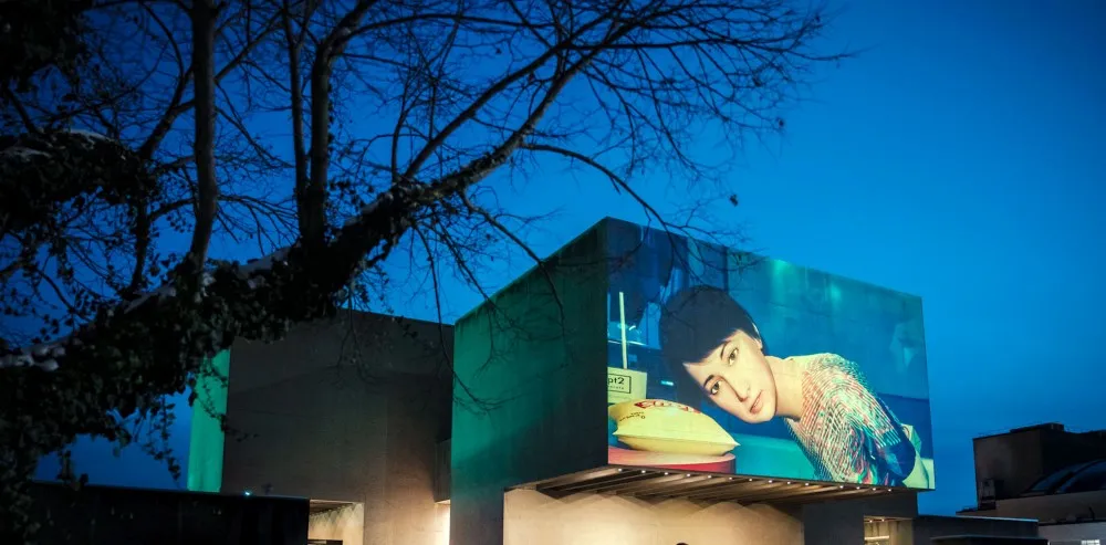 digital billboard in background, tree in foreground