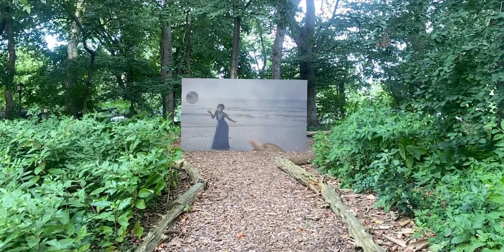a piece of artwork on display outside in a forest