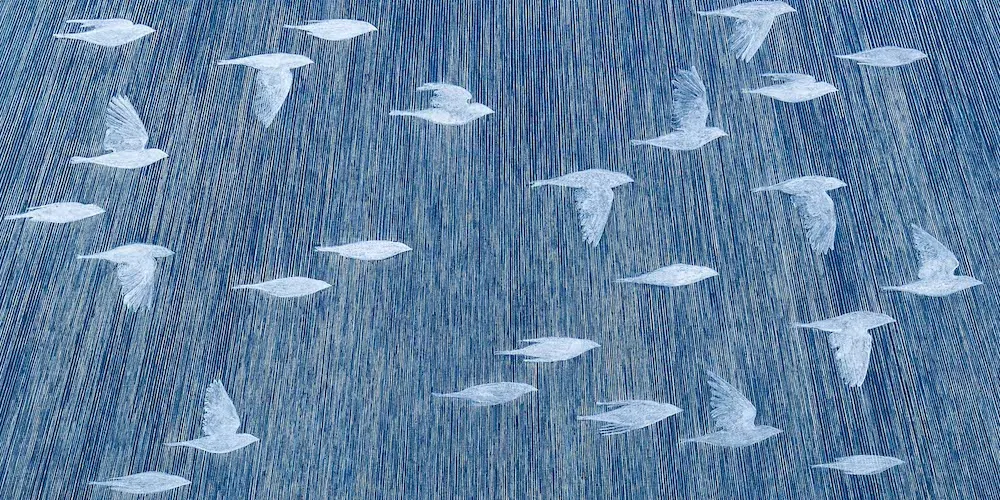 Painting of white birds flying across a blue sky. 