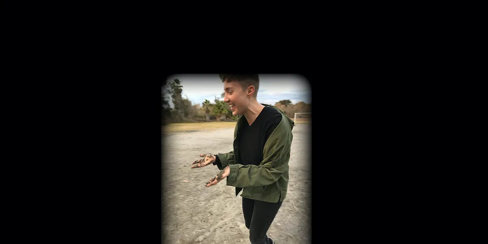 A laughing person with dirt on their hands