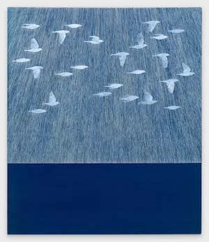 Blue painting of white birds flying. 