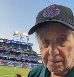 Man wearing black baseball cap. 