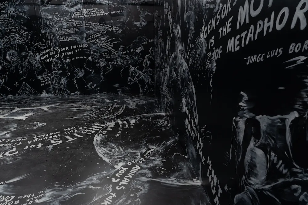 White drawings and text cover a black room. 