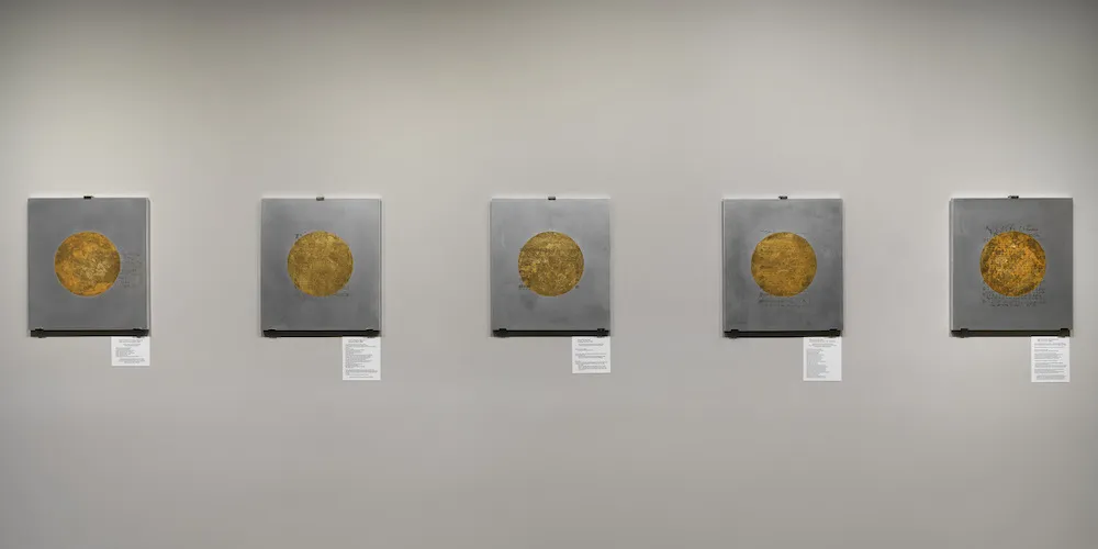 Five artworks in a row with gold circles on square aluminum backgrounds. 