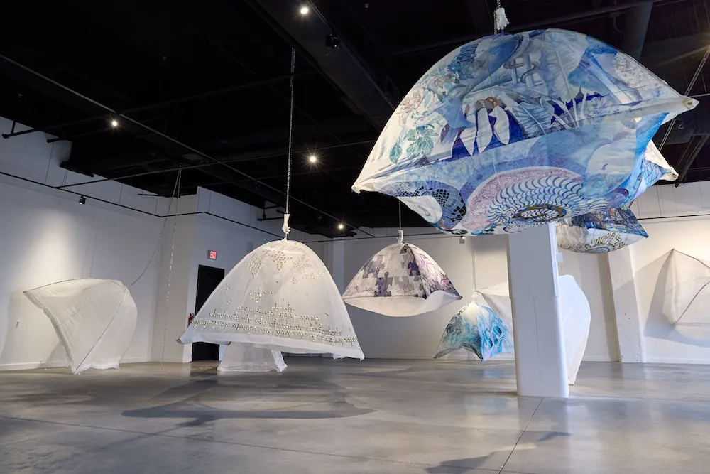 silk organza camping tents arranged in various stages of suspension in an art gallery
