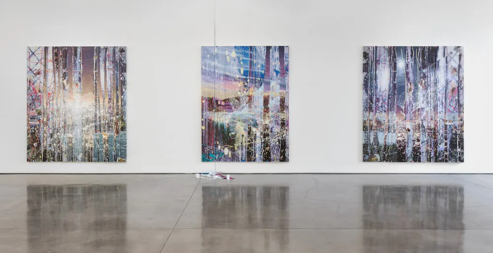 Three large paintings on a gallery wall. 