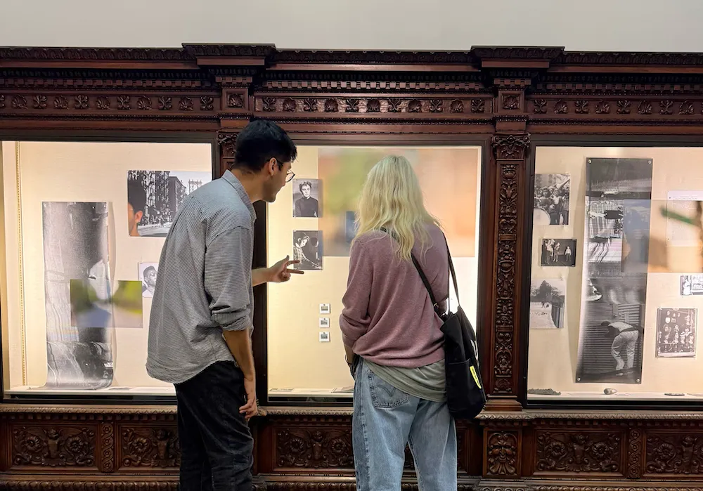 two people look at artwork in display cases