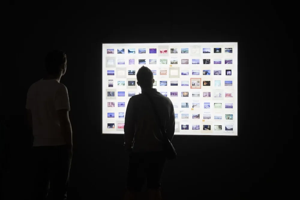 two people look at an art installation in a gallery