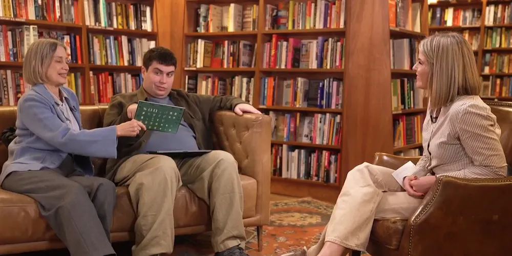 Three people sit on couches in a bookstore