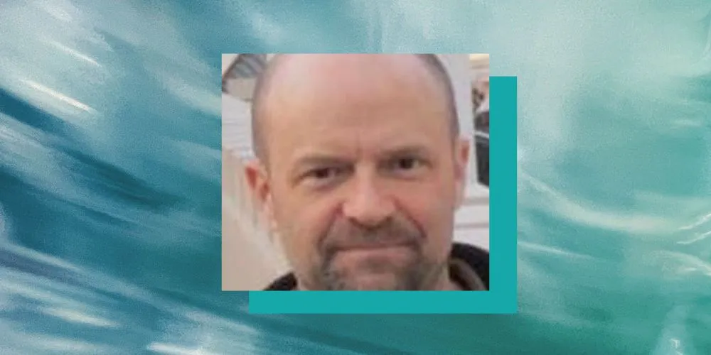 Adam Sexton's headshot on a blue background
