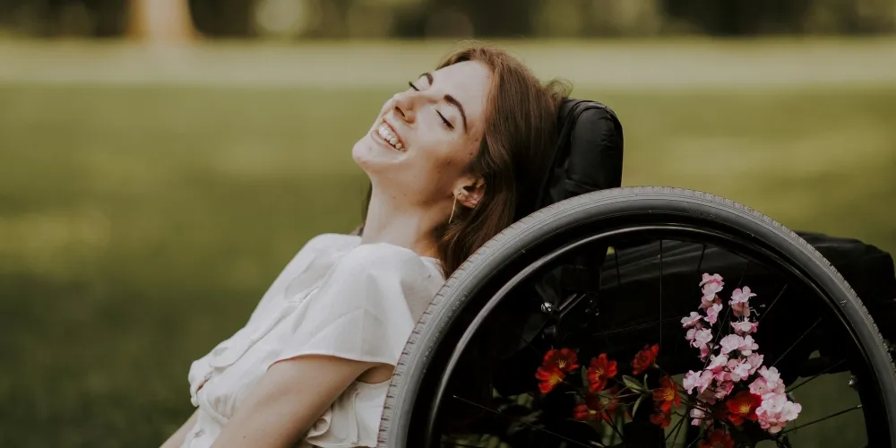 Headshot of Bri Scalesse leaning on a wheelchair.