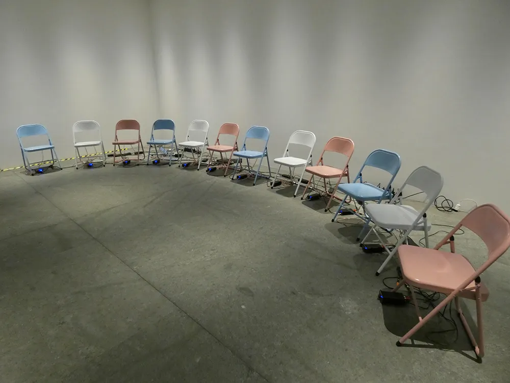 Folding chairs of multiple colors lined up to form a half-circle shape