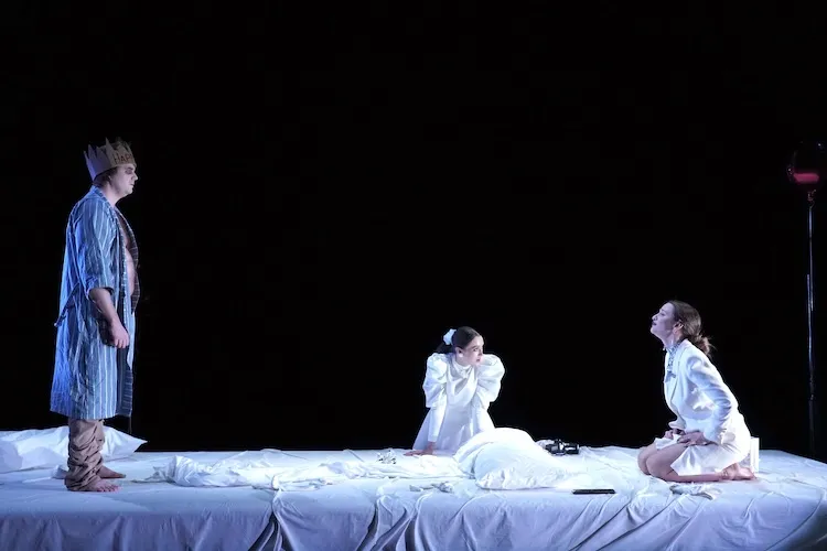 Three actors perform on stage.