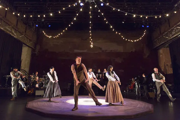 Actors in period clothing dancing onstage