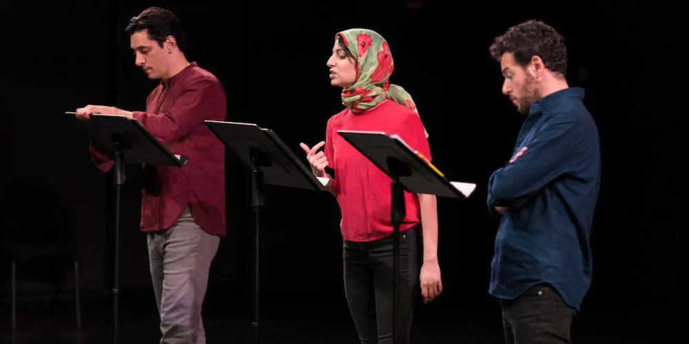 Three people read at podiums 