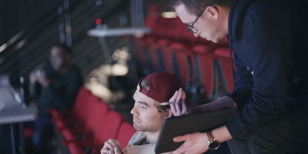 two students discuss work in a theater