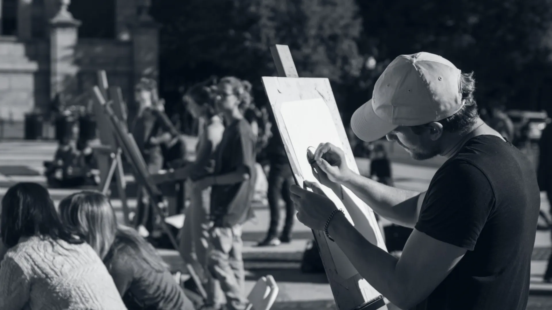 Student sketching on easel outdoors