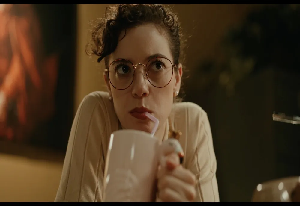 White woman sipping from a cup