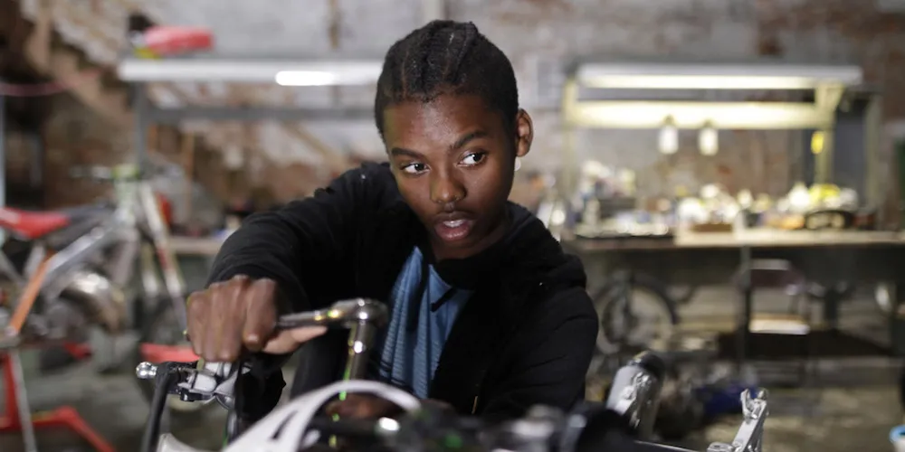 A Black man working in a bike shop.