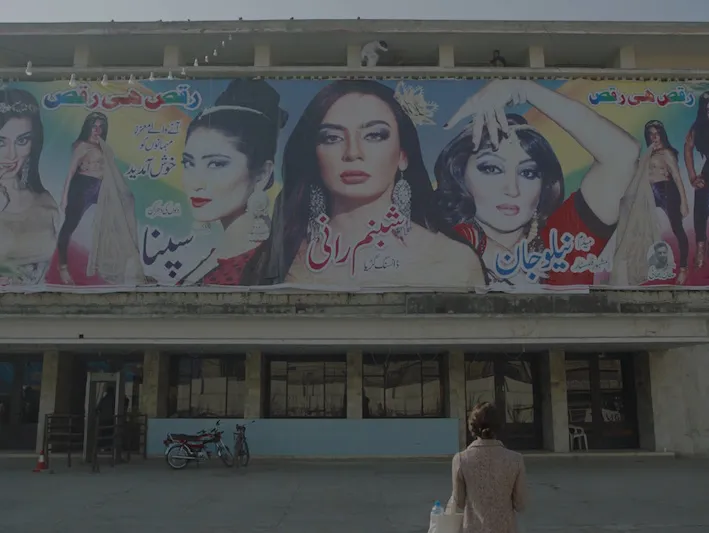 A woman looking at a billboard of other women
