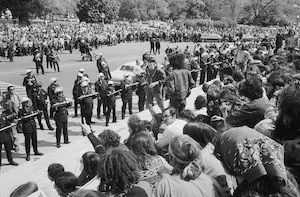 Cops with sticks in front of protestors. 