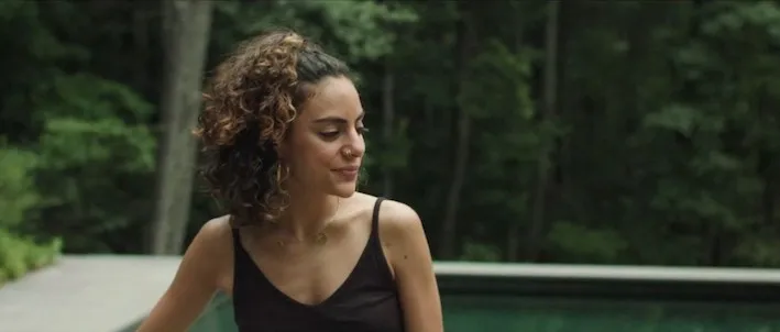 A woman with curly hair and a nose ring