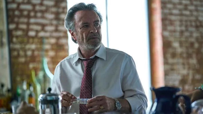 older white man making a drink looking away