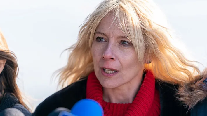 Blond woman speaking into a mic