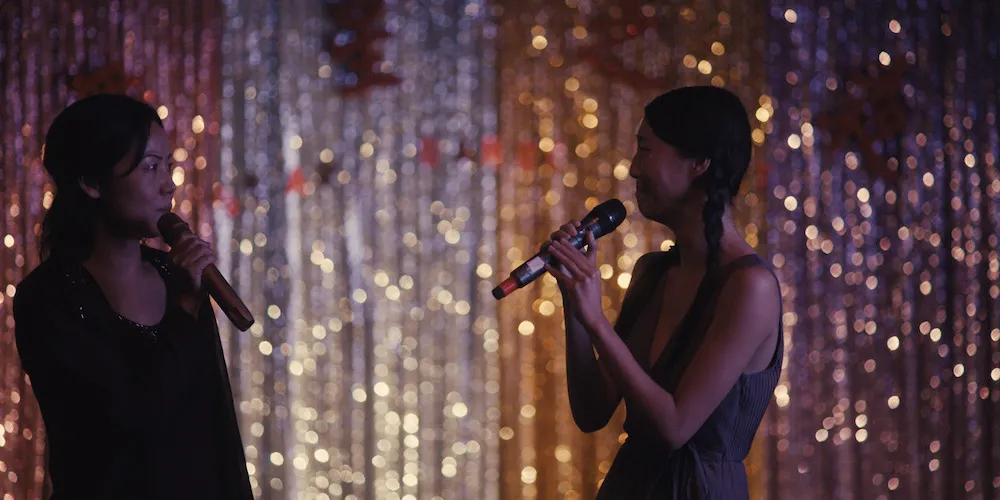 Two Asian woman singing on stage together
