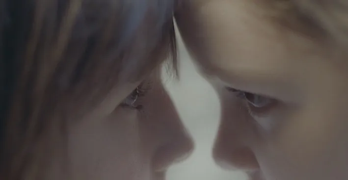 Two people looking at each other, their foreheads pressed together
