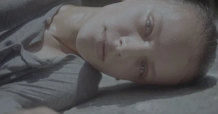 A woman's face, laying down, bright blue eyes