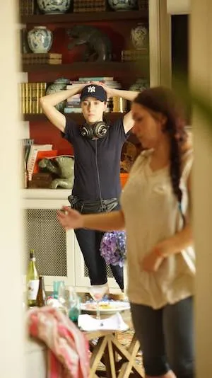 A white woman standing with headphones around her neck taking the scene in.